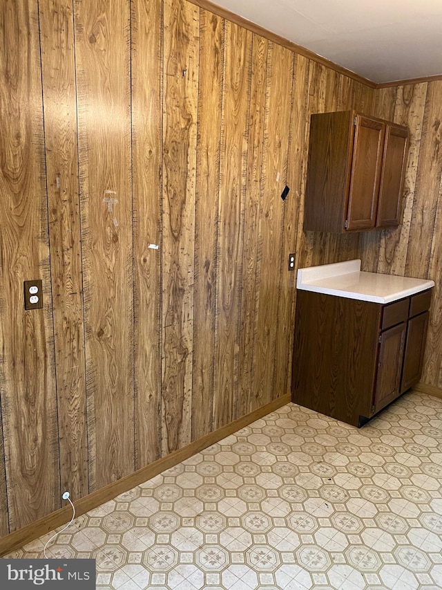 clothes washing area featuring wood walls and light floors