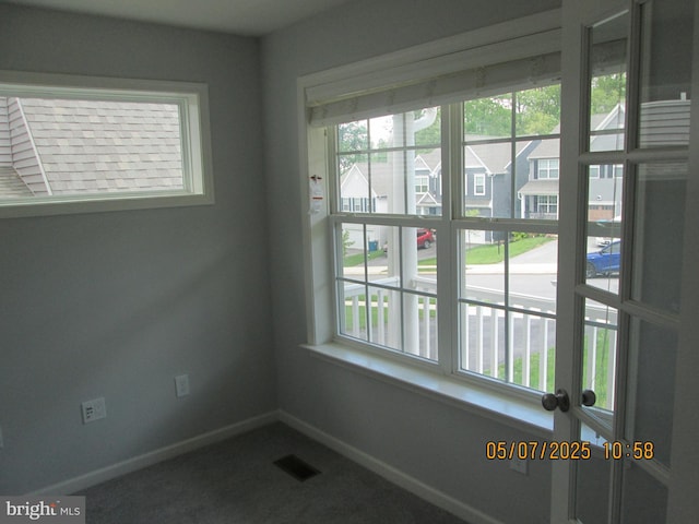 empty room featuring carpet and baseboards