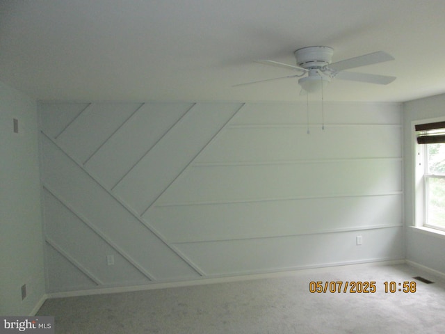 empty room featuring a ceiling fan, carpet, and baseboards
