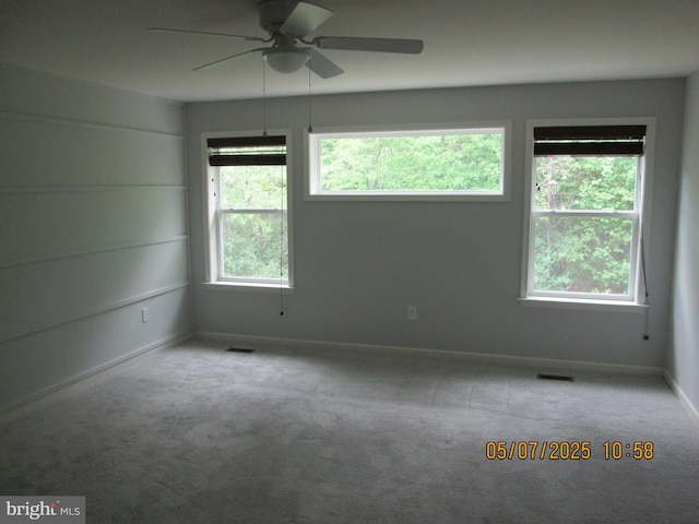 empty room featuring a ceiling fan, carpet flooring, and baseboards