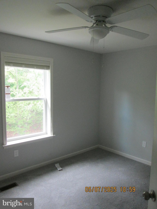 empty room featuring a ceiling fan, carpet flooring, and healthy amount of natural light