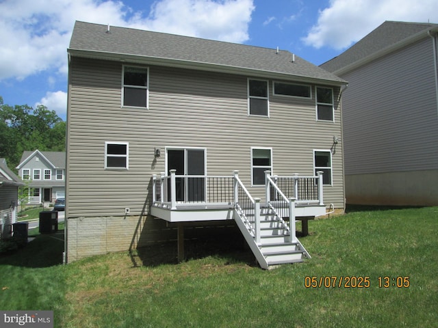 rear view of property with a lawn, a deck, and central AC