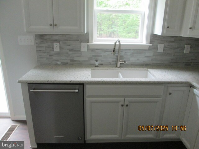 kitchen with dishwasher, a sink, white cabinetry, decorative backsplash, and light stone countertops
