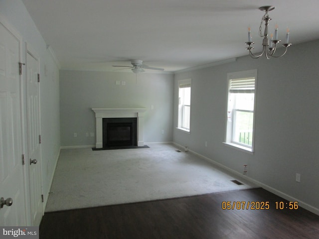 unfurnished living room with a fireplace with flush hearth, a ceiling fan, baseboards, and a chandelier