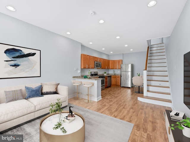 living area featuring stairway, recessed lighting, light wood finished floors, and baseboards