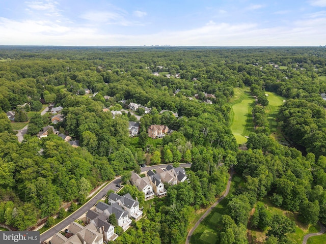 aerial perspective of suburban area with a heavily wooded area and a golf course