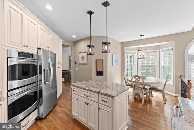 kitchen with appliances with stainless steel finishes, light wood-type flooring, a chandelier, decorative light fixtures, and recessed lighting