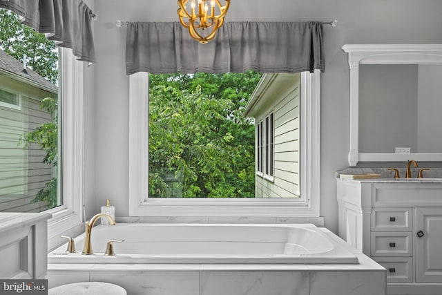 bathroom featuring vanity, a chandelier, and a garden tub