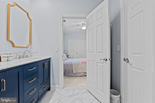 bathroom with baseboards, marble finish flooring, ceiling fan, vanity, and ensuite bathroom