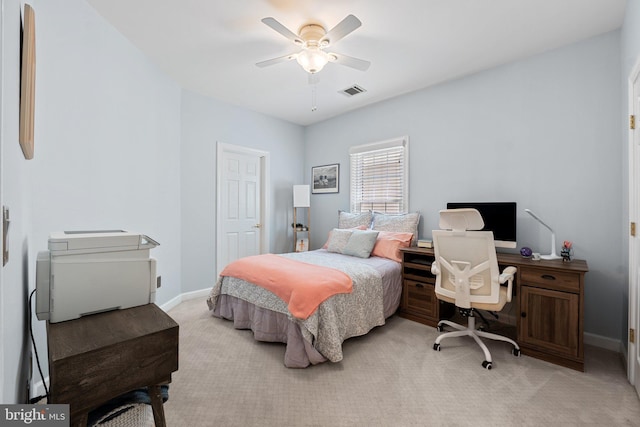 bedroom with light colored carpet, baseboards, a ceiling fan, and an office area