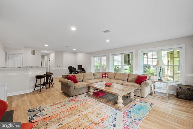 living room featuring an office area, light wood finished floors, baseboards, and recessed lighting