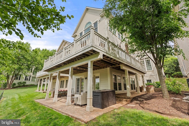 rear view of house featuring a yard, a patio, and a deck