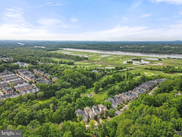 aerial perspective of suburban area featuring a nearby body of water and a forest