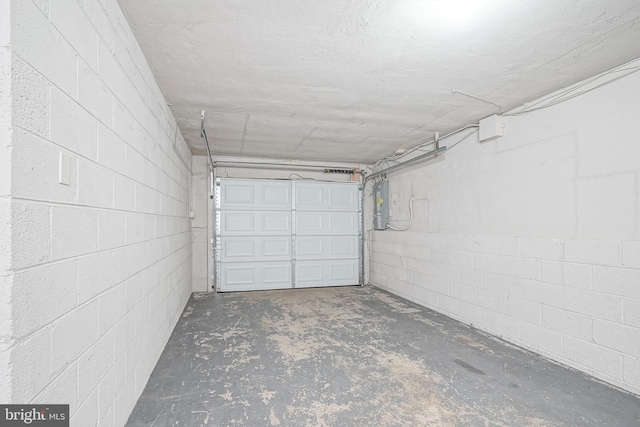 garage featuring electric panel and concrete block wall