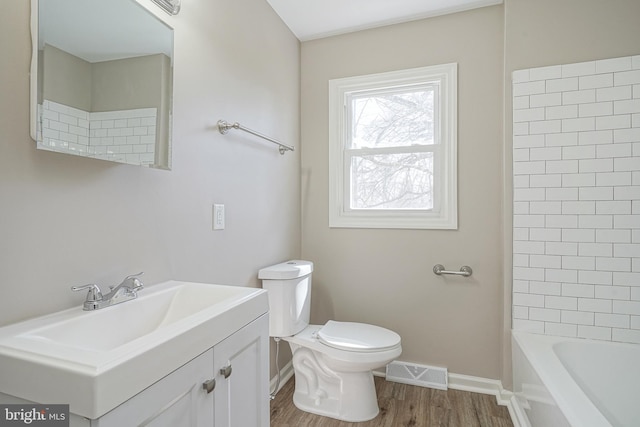 bathroom featuring toilet, baseboards, wood finished floors, and vanity