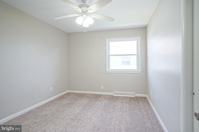 spare room featuring carpet, ceiling fan, and baseboards