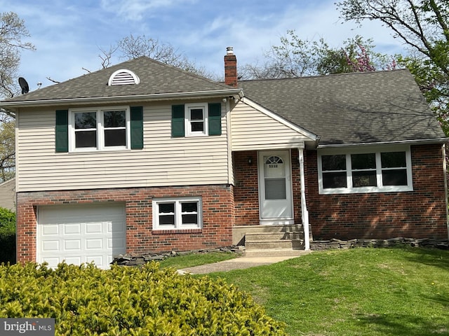split level home featuring a chimney, entry steps, brick siding, a garage, and a front yard