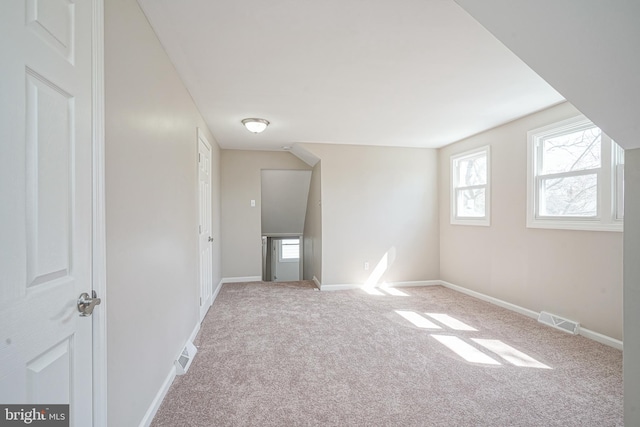 bonus room with carpet flooring, plenty of natural light, and baseboards