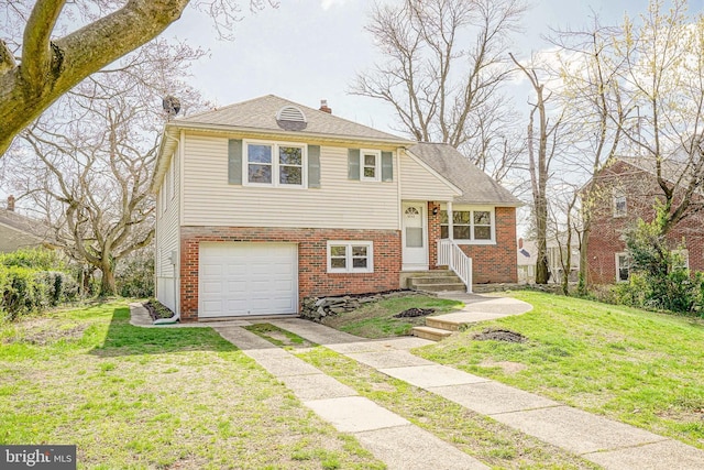 split level home featuring a chimney, brick siding, a front lawn, an attached garage, and driveway