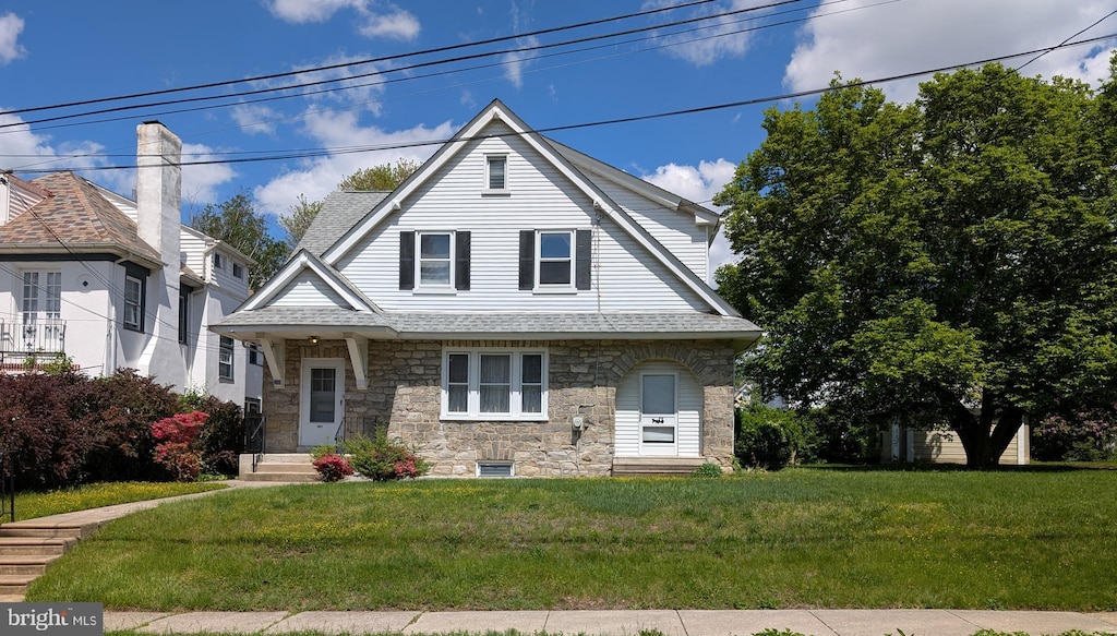 283 Wayne Ave, Lansdowne, PA 19050 - view of front facade featuring stone siding, roof with shingles, and a front yard