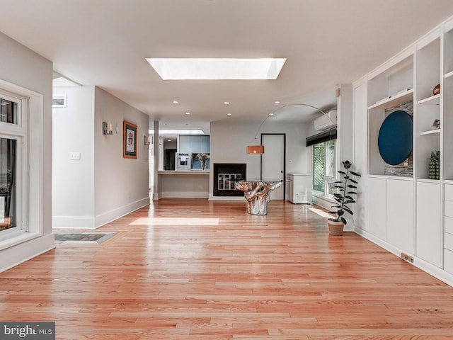 2025 Skyline Rd, Towson, MD 21204 - exercise room featuring a skylight, light wood-style floors, recessed lighting, a wall unit AC, and baseboards