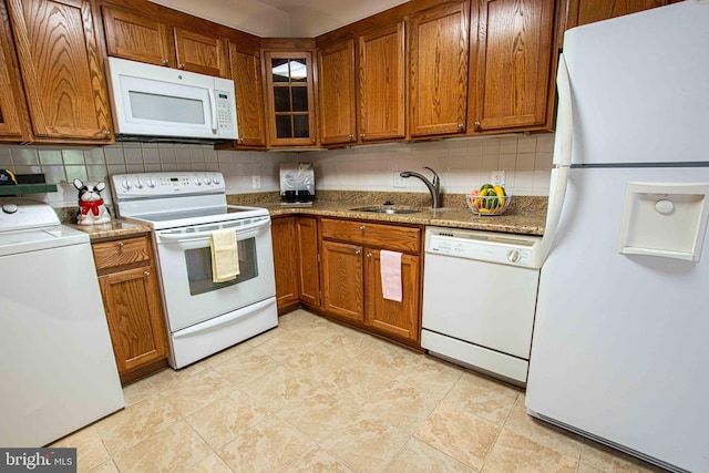 6301 Stevenson Ave Unit 602, Alexandria, VA 22304 - kitchen with white appliances, washer / dryer, a sink, and brown cabinets