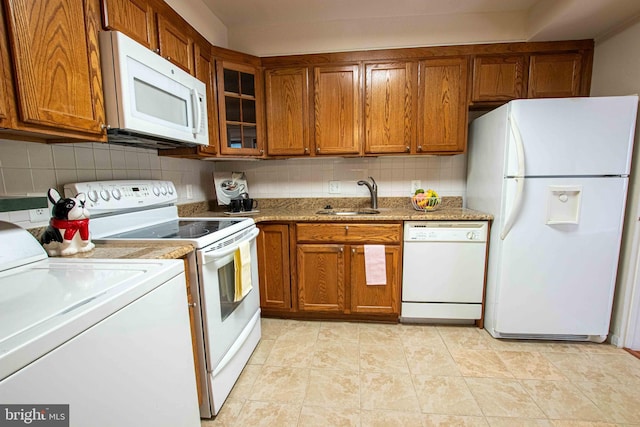 6301 Stevenson Ave Unit 602, Alexandria, VA 22304 - kitchen with white appliances, a sink, washer / dryer, and brown cabinets