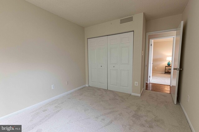 6301 Stevenson Ave Unit 602, Alexandria, VA 22304 - unfurnished bedroom with carpet flooring, a closet, baseboards, and a textured ceiling