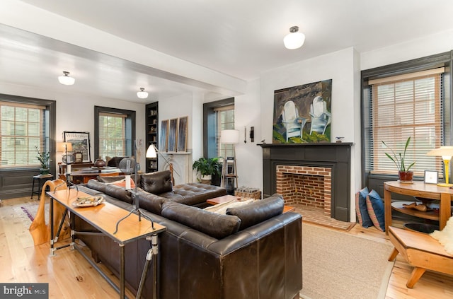 living area with light wood finished floors and a fireplace with flush hearth