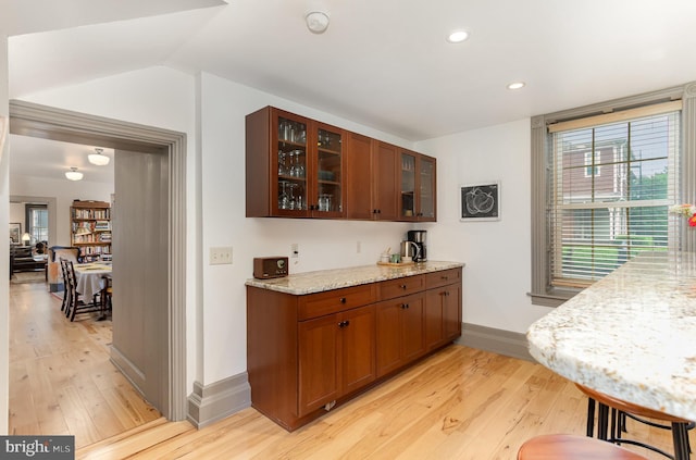 bar area featuring light wood-style floors, baseboards, recessed lighting, and lofted ceiling