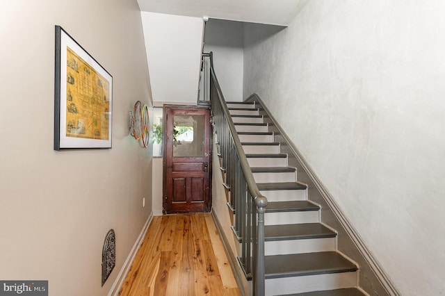 staircase with wood finished floors and baseboards