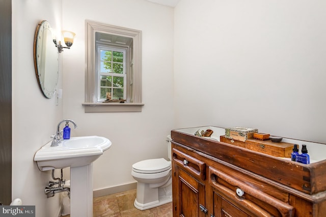 bathroom featuring toilet and baseboards