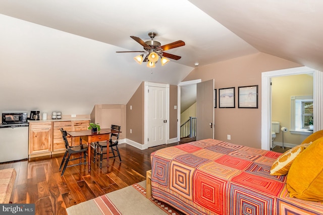 bedroom with dark wood finished floors, lofted ceiling, ensuite bathroom, and a closet