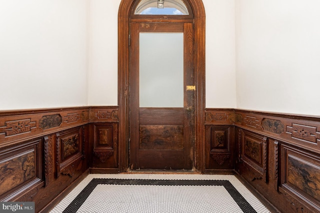 foyer entrance featuring wainscoting and a decorative wall
