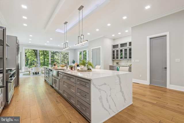 5706 Nevada Ave NW, Washington, DC 20015 - kitchen featuring stainless steel stove, gray cabinets, a sink, crown molding, and a large island