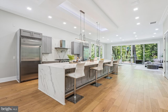 5706 Nevada Ave NW, Washington, DC 20015 - kitchen featuring stainless steel built in fridge, gray cabinetry, wall chimney range hood, a large island, and light wood-style flooring