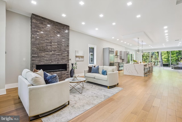 5706 Nevada Ave NW, Washington, DC 20015 - living area featuring a stone fireplace, light wood-type flooring, baseboards, recessed lighting, and ornamental molding