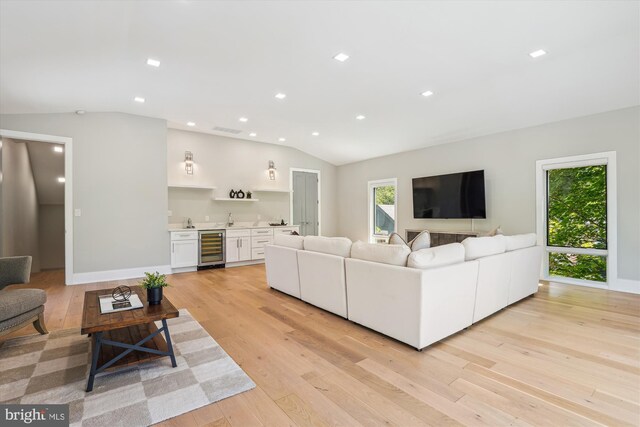 5706 Nevada Ave NW, Washington, DC 20015 - living room featuring beverage cooler, vaulted ceiling, wet bar, light wood finished floors, and recessed lighting