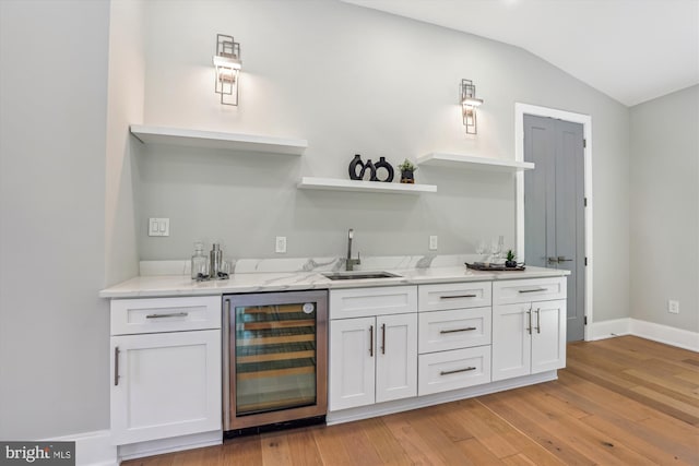 5706 Nevada Ave NW, Washington, DC 20015 - indoor wet bar featuring beverage cooler, light wood-style floors, lofted ceiling, and baseboards