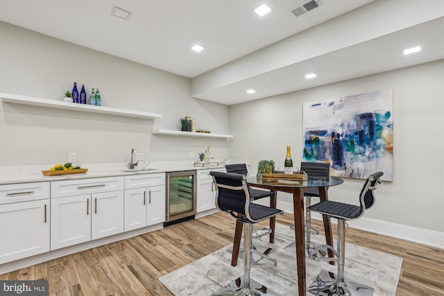 5706 Nevada Ave NW, Washington, DC 20015 - indoor wet bar with beverage cooler, light wood-style floors, baseboards, and recessed lighting