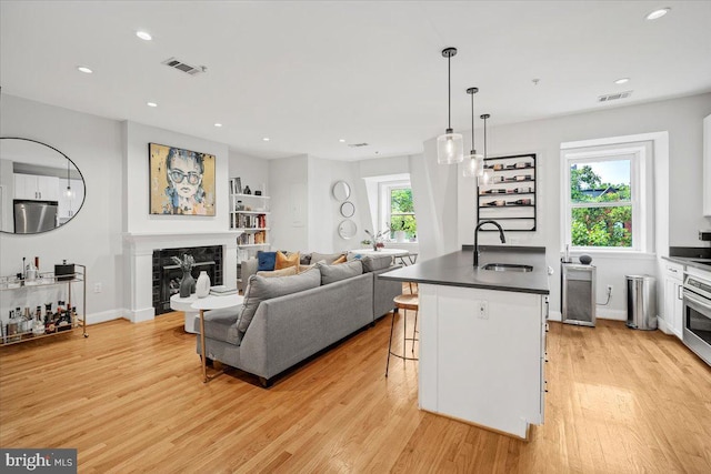 1407 15th St NW Unit 4, Washington, DC 20005 - living room featuring a glass covered fireplace, light wood finished floors, recessed lighting, baseboards, and beverage cooler