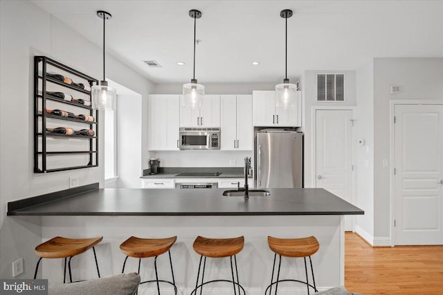 1407 15th St NW Unit 4, Washington, DC 20005 - kitchen with a sink, appliances with stainless steel finishes, dark countertops, a breakfast bar area, and recessed lighting