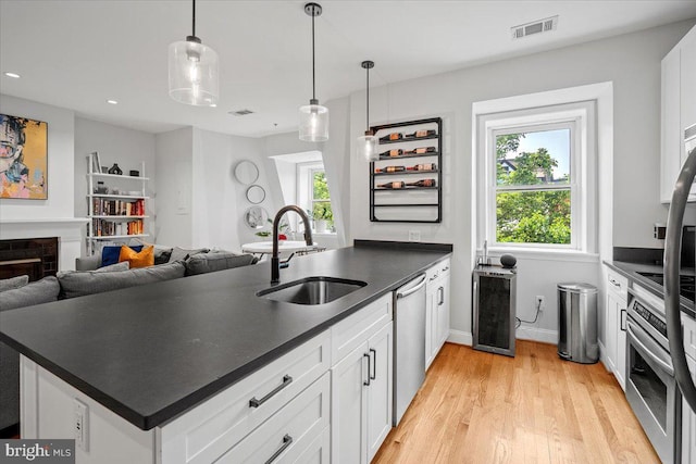 1407 15th St NW Unit 4, Washington, DC 20005 - kitchen featuring a sink, appliances with stainless steel finishes, dark countertops, light wood-style floors, and recessed lighting