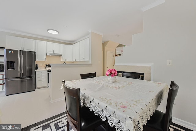 dining area with baseboards, crown molding, and a premium fireplace