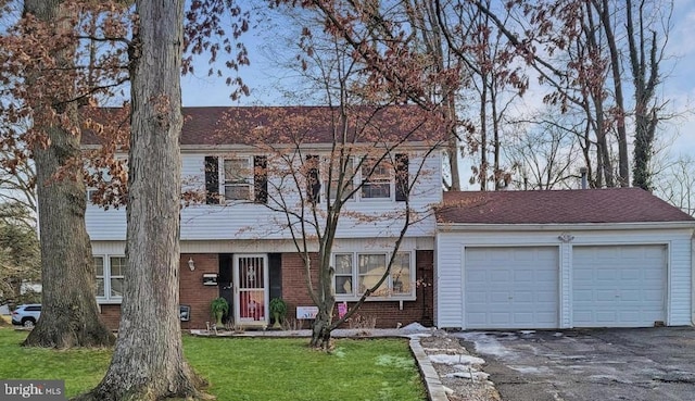 59 Emerald Ln, Willingboro, NJ 08046 - colonial-style house with an attached garage, asphalt driveway, a front lawn, and brick siding