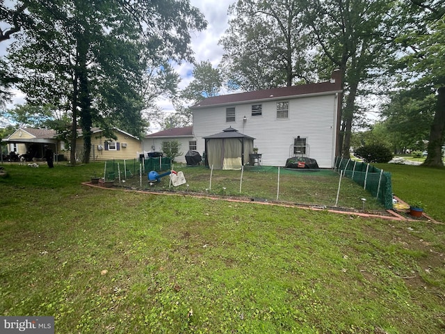 59 Emerald Ln, Willingboro, NJ 08046 - back of property with a chimney, a lawn, and a gazebo