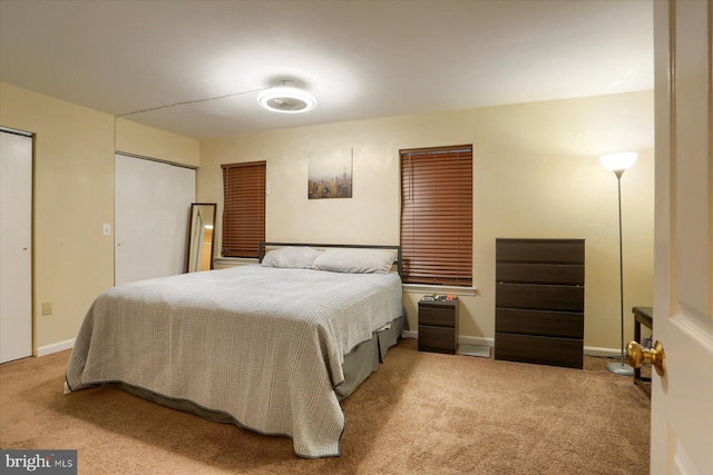 carpeted bedroom featuring multiple closets and baseboards