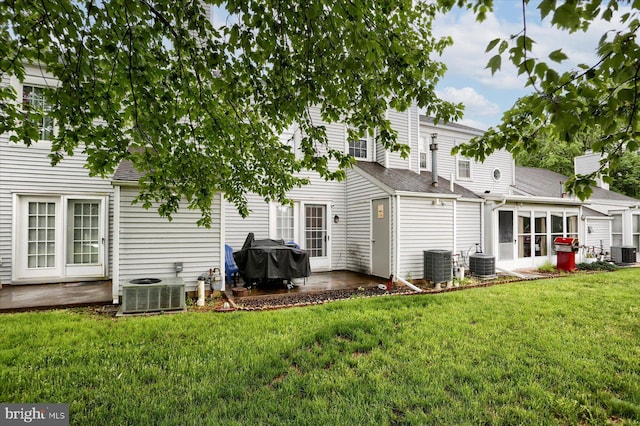 rear view of property with central AC, a patio, and a sunroom
