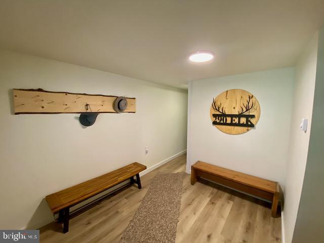 hallway featuring wood finished floors and baseboards