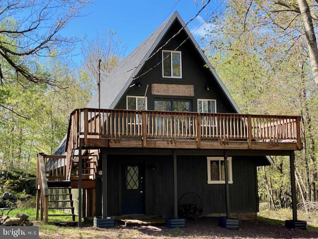 rear view of house featuring stairway and a deck